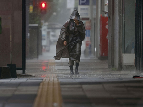 A passerby walks amid heavy rain and wind caused by Typhoon Khanun in Kagoshima, Japan (Image Credit: Reuters)