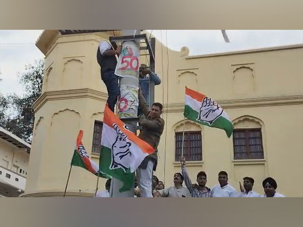 Former MP minister Jitu Patwari seen putting poster (Photo/ANI)