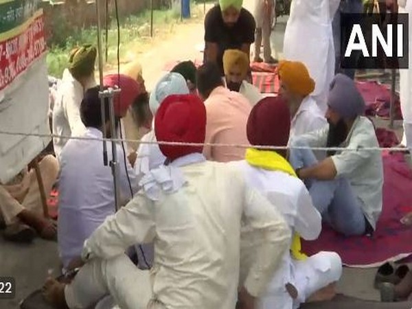 Farmers sitting in protest (Photo/ANI)