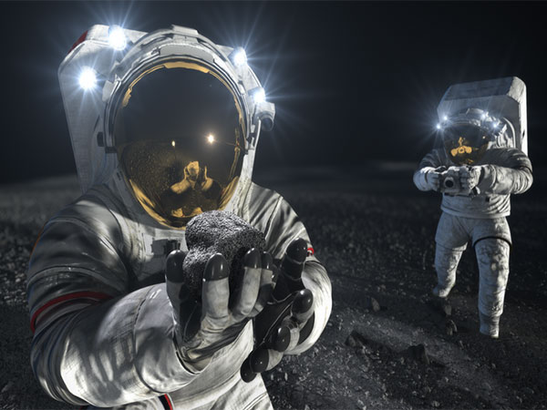 Two suited crew members work on the lunar surface (Photo Credit: NASA)