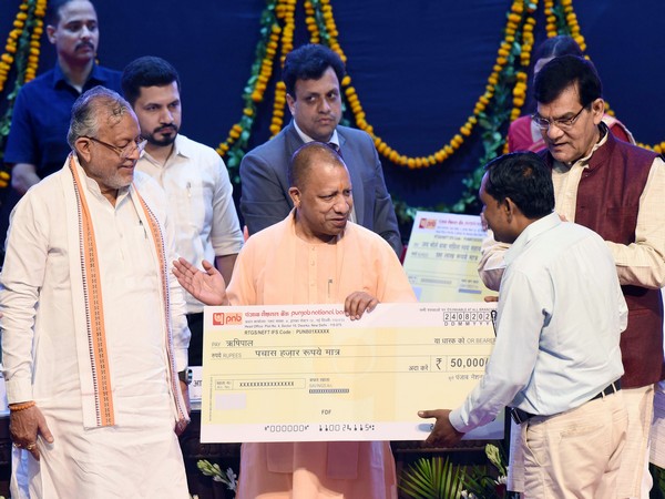 UP CM Yogi Adityanath presents cheques to beneficiaries under the 'PM Swanidhi' and 'Self Help Group Loan Scheme' (Photo/ANI)