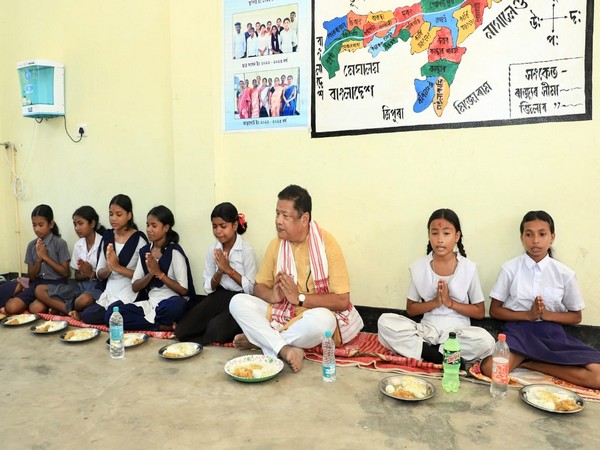 Assam Education Minister Ranoj Pegu joins students for a mid-day meal in a school in Kamrup-Metro (Photo/ANI)