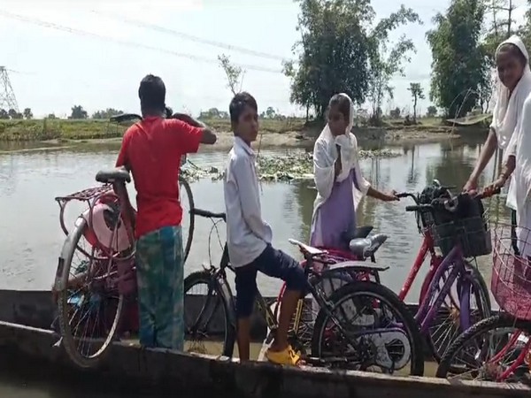 Students from Assam's Sila Mari village cross stream on boat on way to school (Photo/ANI)