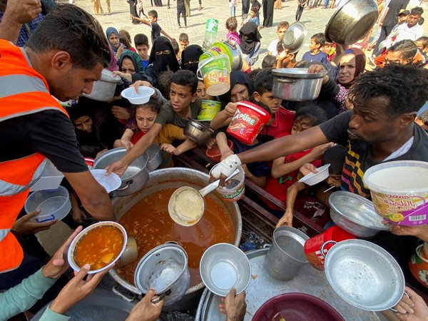 Palestinians gather to get their share of charity food in Rafah (Photo Credit: Reuters)