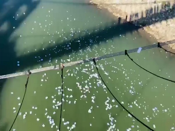 The residents threw power bills in the river to protest against the spike in electricity prices (Photo/ANI)