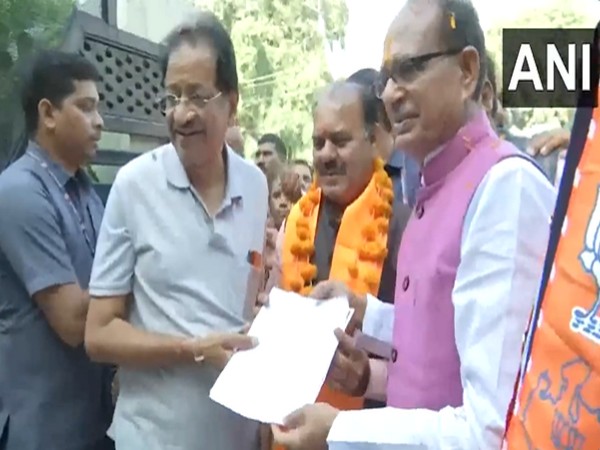 Madhya Pradesh CM Shivraj Singh Chouhan distributing voter slip (Photo/ANI)