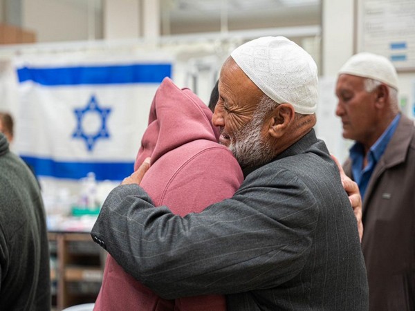 Freed captive Bilal Ziyadne (left) reunites with his family on November 30 (Photo/TPS)