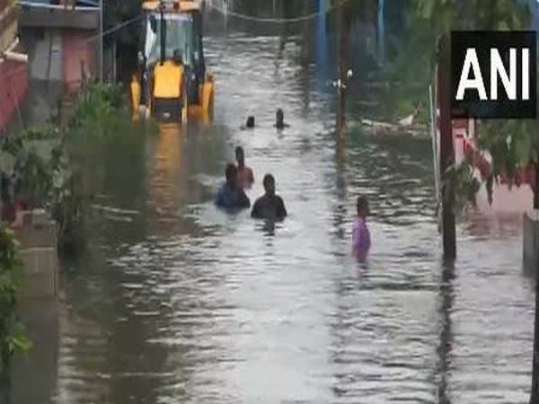 People wade through neck deep water in Chennai (Photo/ANI)