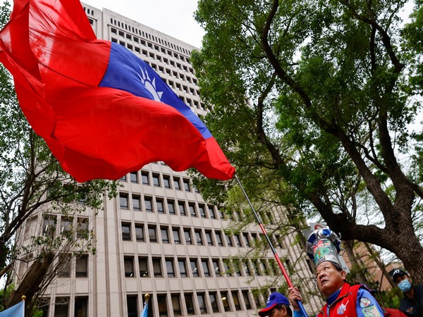 A man waves a Taiwanese flag outside of the Central Election Commission, in Taipei (Photo Credit: Reuters)