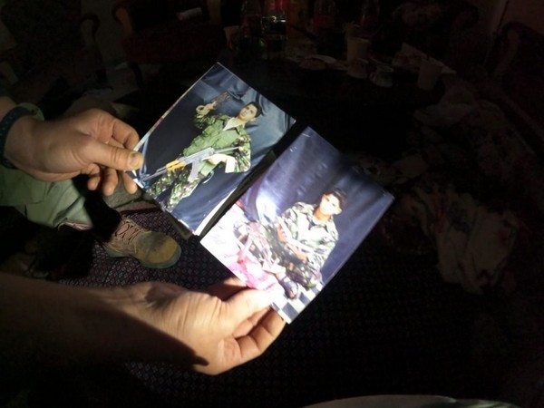 An Israeli soldier holds photos of Palestinian children dressed in Hamas uniforms (Photo/TPS)