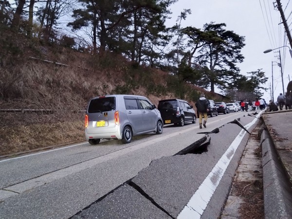 People walk along a road damaged by an earthquake, in Wajima (Image Credit: Reuters)