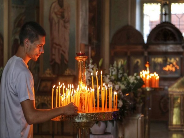 A man lights candles inside Jaffa's St. Peter's Russian Orthodox Church (Photo/TPS)
