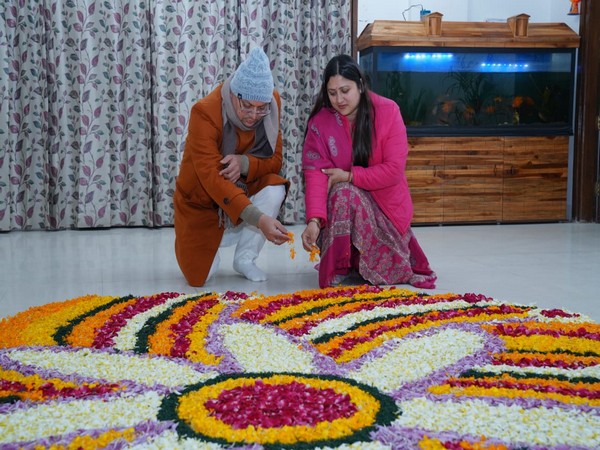 Uttarakhand Chief Minister Pushkar Singh Dhami along with his wife make rangoli of flowers on Sunday. (Photo/ANI)