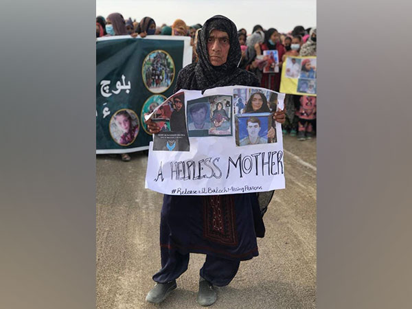 A Baloch mother holding a poster saying 