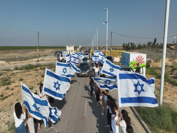 Evacuated residents of the village of Shlomit wave flags in celebration (Photo/TPS)