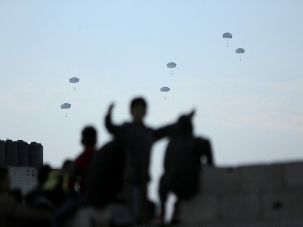 People watch as US military carries out its first aid drop over Gaza (Photo/Reuters)