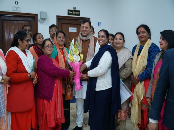 CM Pushkar Singh Dhami with officials of Uttarakhand Asha Health Workers Union, Anganwadi workers on Sunday. (Photo/ANI)