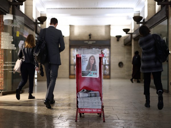Commuters walk past copies of the Evening Standard at a subway station in London (Photo/Reuters)
