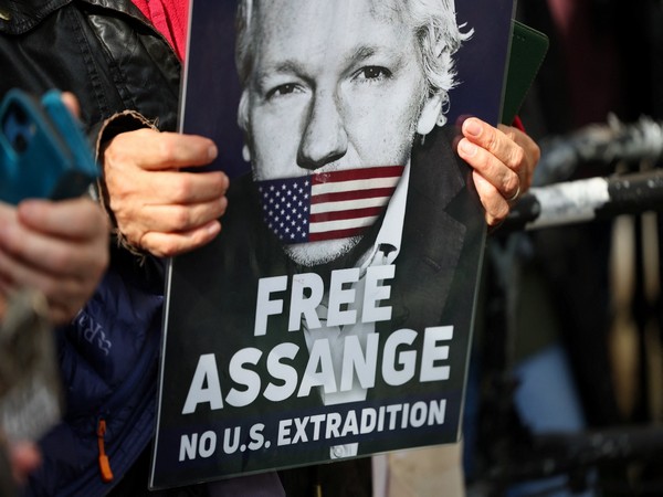 Supporters of Julian Assange holding his poster (Photo credit: Reuters)