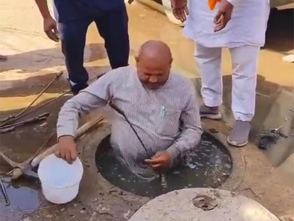 BJP councillor Devendra Rathore cleaning sewer (snap from the viral video)