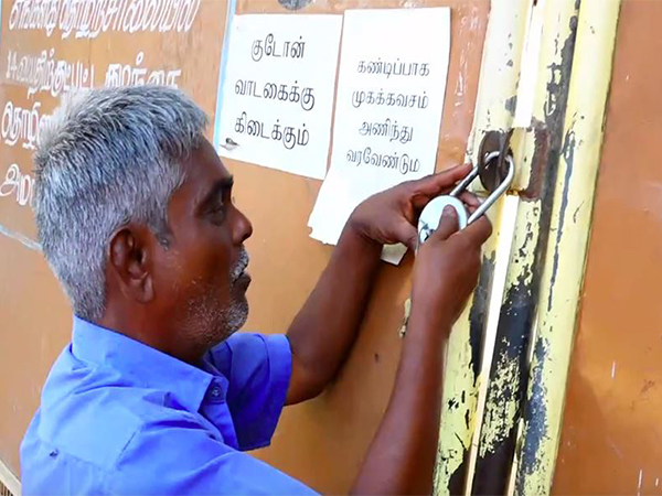 Worker putting lock on a matchbox factory ahead of production halt of matches (Photo/ANI)