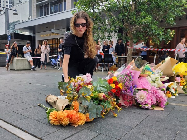People offer flowers for the victims of Saturday's stabbings at Bondi Junction in Sydney (Photo/Reuters)