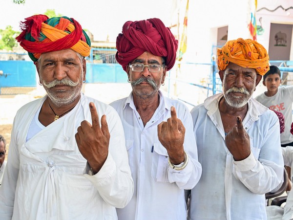 People show their ink-marked finger after casting their votes in Ajmer (Photo/ANI)