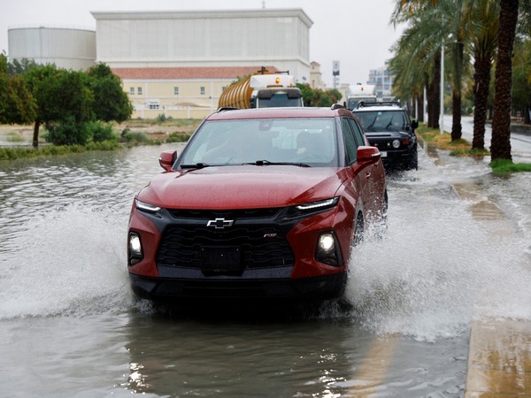 Cars drive through flooded road after rainstorm in Dubai (Image Credit: Reuters)