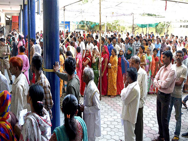 Voters wait in queues to cast their votes at a polling booth in Bhopal. (Photo/ANI)