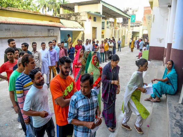 Voters waiting in queues to cast their votes in Etawah in UP. (Photo/ANI)