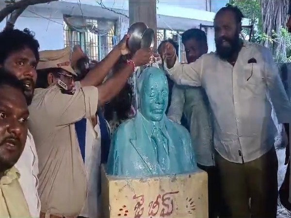 Protesters, along with police, perform 'pal abhishekam' at Ambedkar's statue. (Photo/ANI)