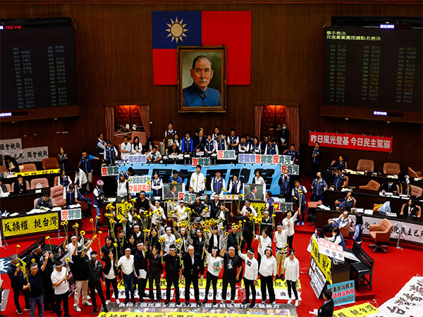 DPP's lawmakers hold sunflowers while Han Kuo-yu, the parliament speaker, watches at a parliamentary session, in Taipei (Photo/Reuters)