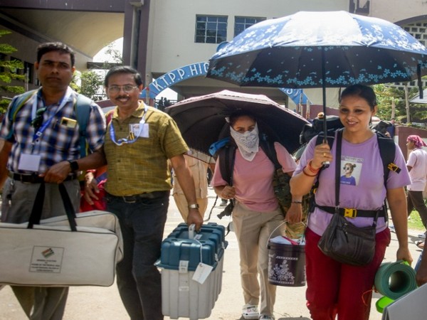 Polling officials carrying EVMs and other election material for their respective polling booths in East Medinipur. (Photo/ANI)