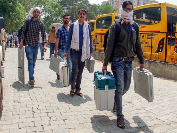 Polling officials carrying EVMs and other election material for their respective polling booths. (Photo/ANI)
