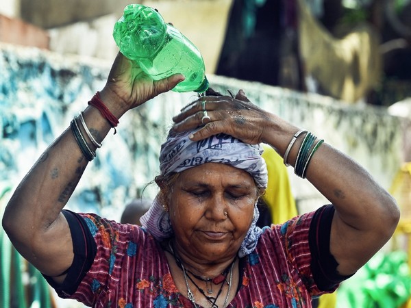 A woman pours water on her head to deal with hot weather in Delhi. (Photo/ANI)
