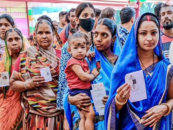 Voters stand in a queue to cast their vote in Dumka (Photo/ANI)