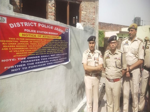 Police officials after pasting notice of attatchment (Pic credit/Police)