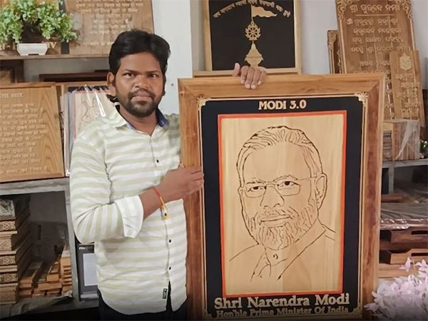 Odisha Woodcraft Artist Arun Sahu with portrait (Image/ANI)