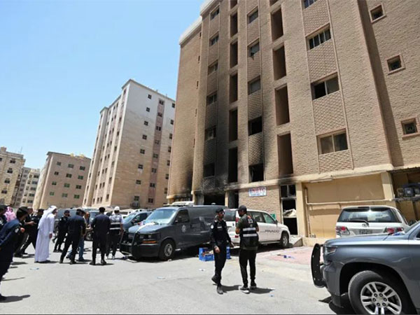 Police officers seen outside the building that caught fire in Mangaf, southern Kuwait [Reuters]