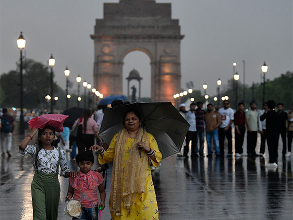 People walk on Kartavya Path during a light rain. (File Photo/ANI)