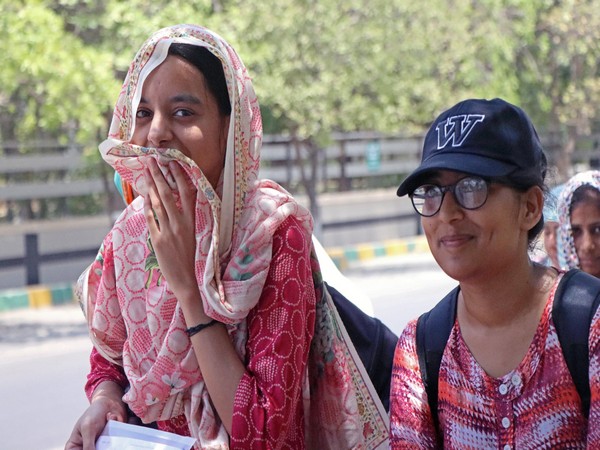 Students cover their faces to protect themselves from the scorching sun. (File Photo/ANI)