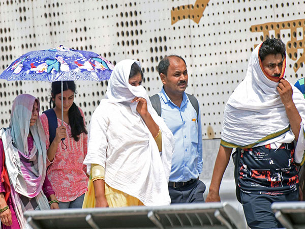 People cover themselves to protect from the scorching heat. (File Photo/ANI)