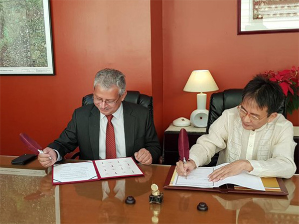 Ravi Sharma (left) and Huan Wei (right) sign the memorandum