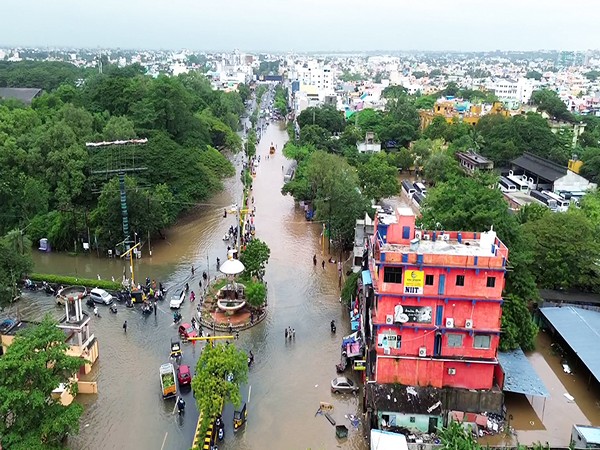 Commuters wade through a flooded road amid Cyclone Fengal (Photo/ANI)