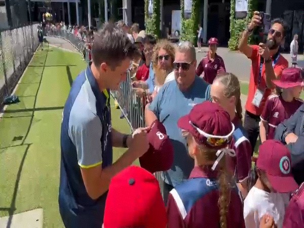 Skipper Pat Cummins signing a hat for a fan. (Photo- ANI)