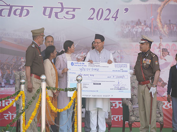  CM Dhami presents scholarship to meritorious children. (Photo.ANI)