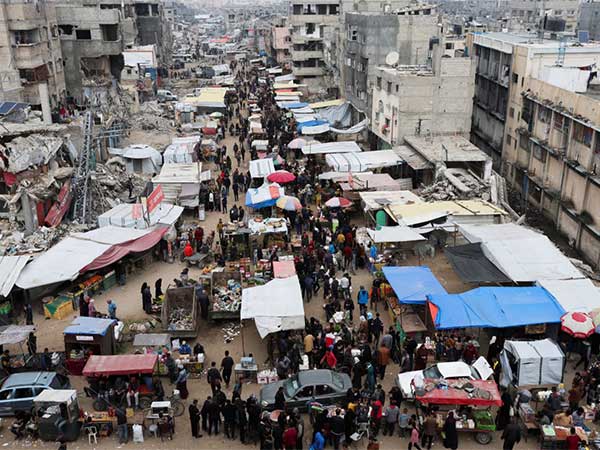Palestinians walk on a street market amid ceasefire negotiations, in Khan Younis in the southern Gaza Strip (Image/Reuters)