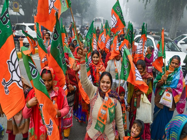 BJP supporters holding party symbol flags raise slogans during the 'Padyatra' of party candidate from the New Delhi Assembly seat (Photo/ANI)