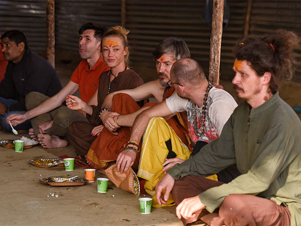 Foreign devotees enjoy their meals after taking a dip at Triveni Sangam during the Maha Kumbh 2025 (Photo/ANI)