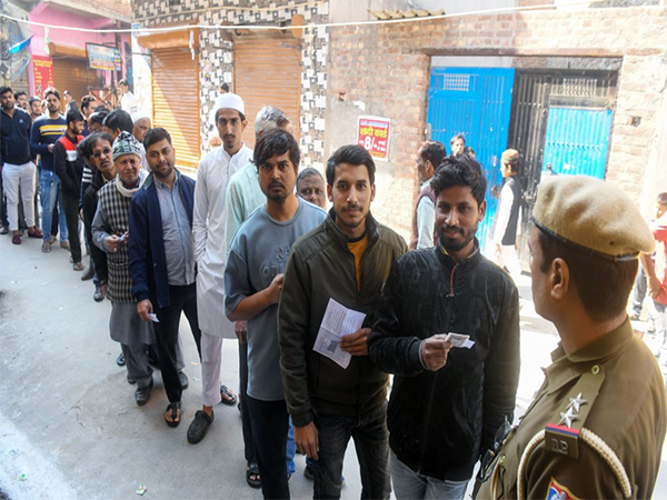 Voters in a queue to cast their ballot in Delhi Assembly elections. (Photo/ANI)